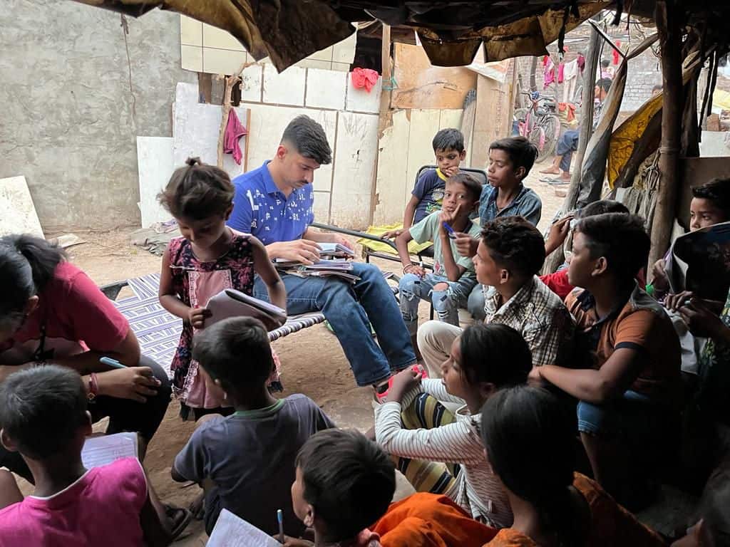 Parth reading with children in Jagatpura village