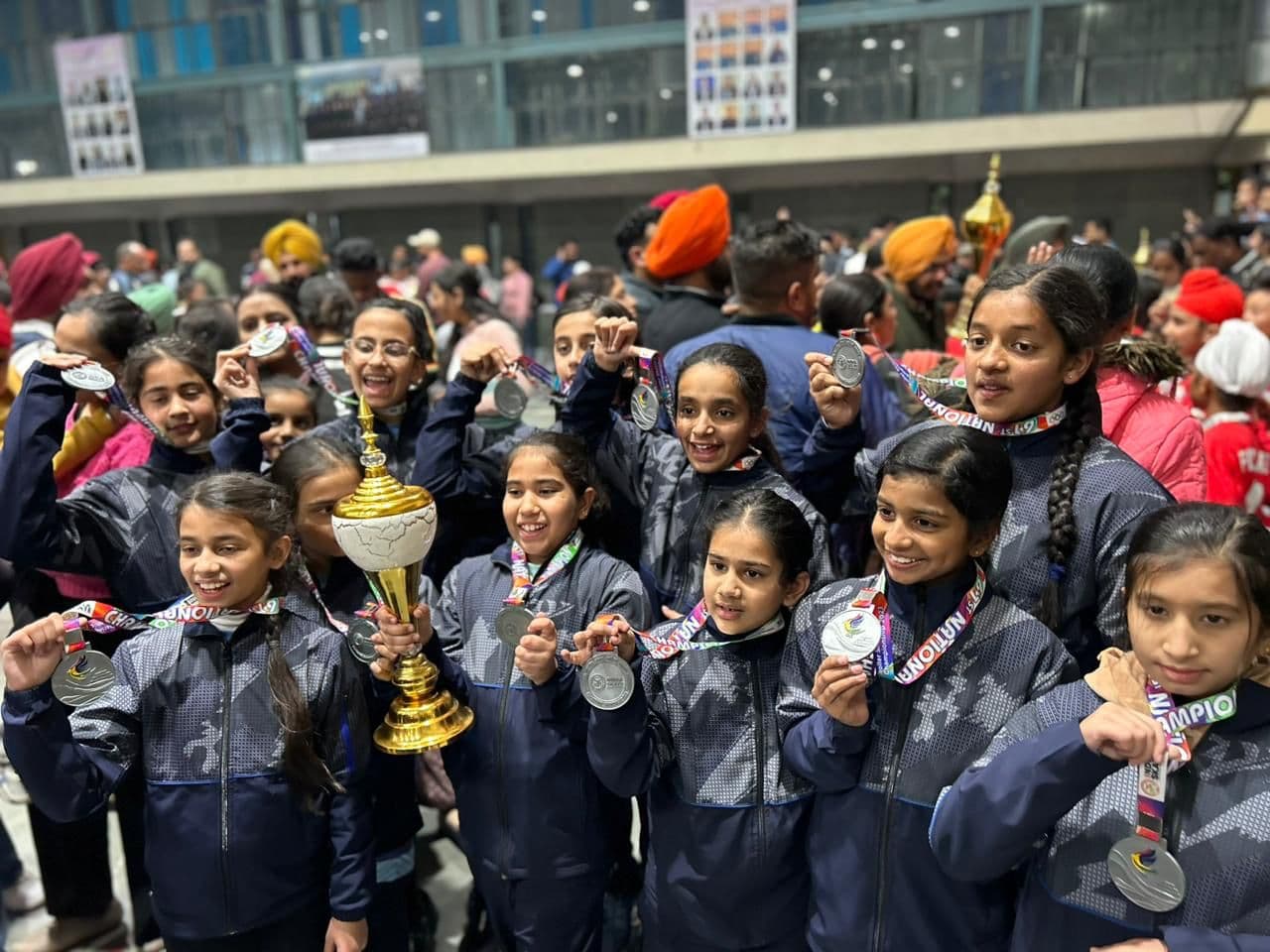 Students celebrating with medals and a trophy at the nationals