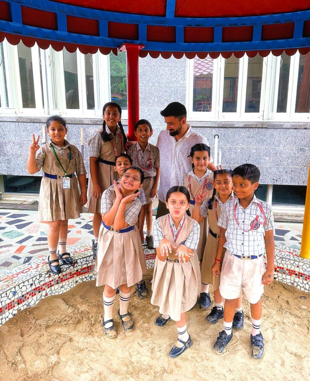 Parth with young students in the school playground